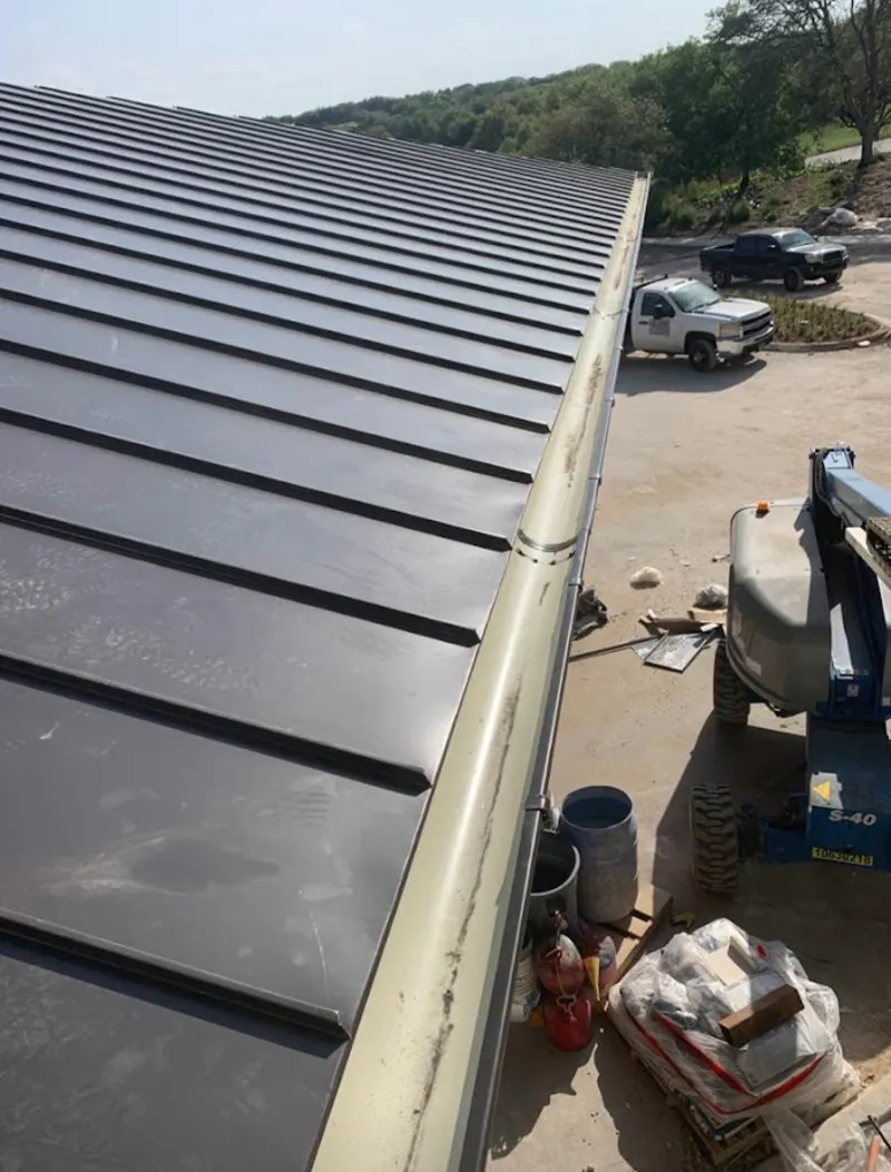 Standing seam panel and gutter detail on a metal roofing jobsite in Rockport